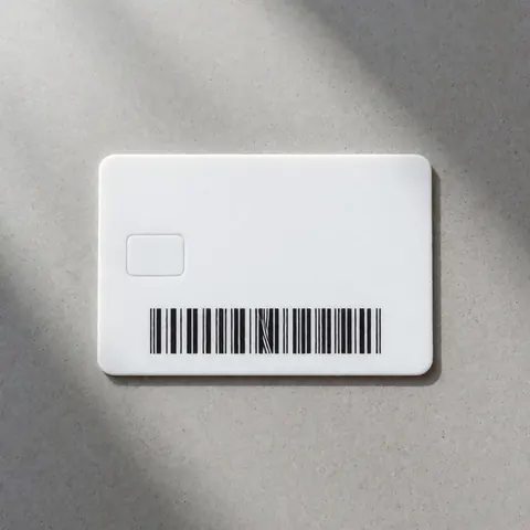 White plastic parking access card featuring a barcode and chip resting on a gray concrete surface with soft diffuse lighting
