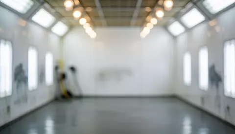 White walls and reflective gray floor with LED bokeh lights, serving as a professional background for text overlays in automotive advertising.