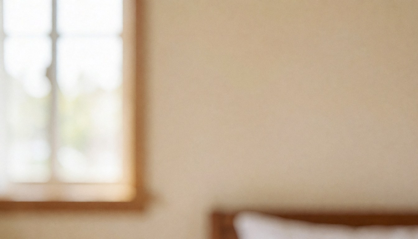 Warm bedroom wall background featuring a window frame and bed headboard with soft lighting and warm tones suitable for text overlay