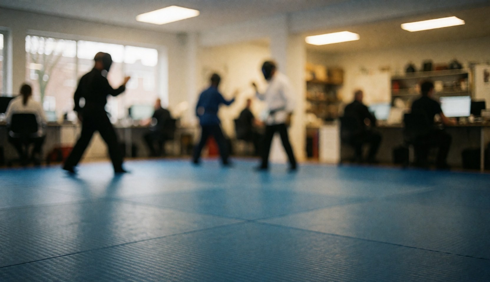 Blue training mats in a martial arts studio with ceiling lights, suitable as a background for text overlays.