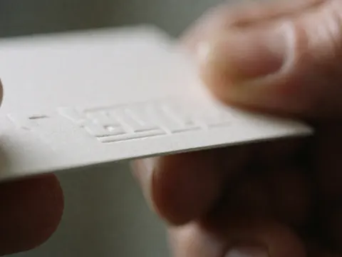 Close-up of an embossed business card with textured paper, blurred background, macro photography for business professionals