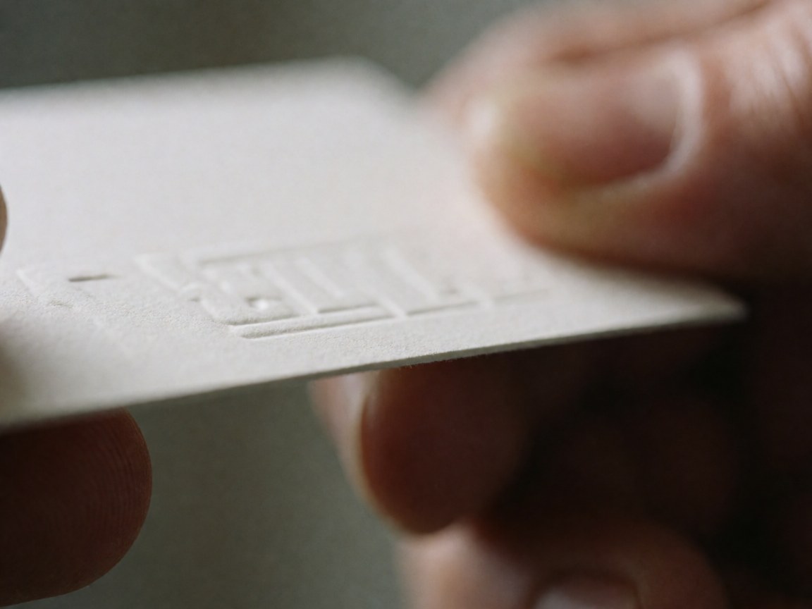 Close-up of an embossed business card with textured paper, blurred background, macro photography for business professionals