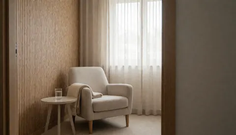 A quiet therapy room featuring a comfortable chair, a small side table with water, and natural light streaming through a window, ideal for a professional website hero section.