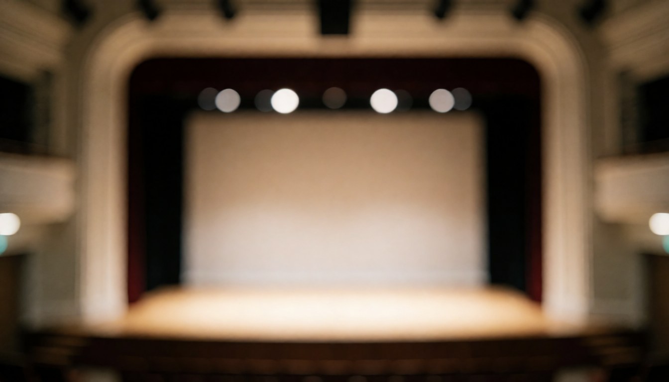 Empty theater stage with warm lighting and proscenium arch, blurred background suitable for text overlay in theater workshops