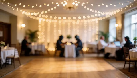 Wooden dance floor with fairy lights and white tablecloths for wedding reception background