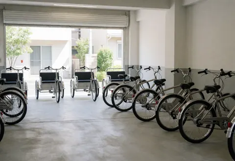 Bicycle taxis and cargo tricycles ready for service in a modern garage with polished concrete floors and white walls.