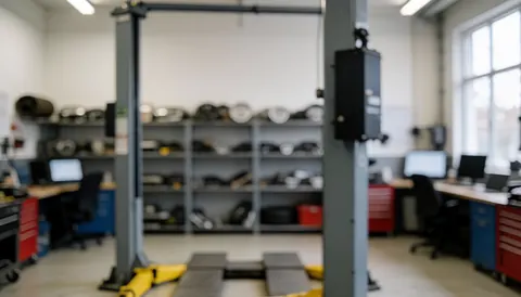Neutral professional background of an auto body and paint workshop featuring a forklift and spare parts shelves with industrial lighting.