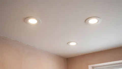 White ceiling with three illuminated recessed LED lights and terracotta stucco walls providing warm clean lighting for residential electrician websites