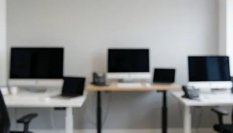 Clean studio background featuring computer monitors and desks, ideal for corporate text overlays and professional design projects.