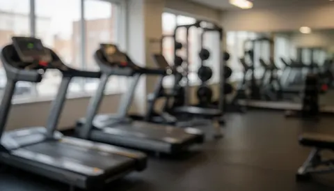 Warm-toned gym background featuring exercise mats and weights, suitable for text overlay with a professional atmosphere