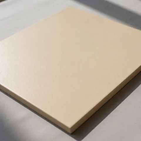 Close-up of a beige synthetic stucco panel featuring a uniform texture, displayed against a neutral gray background for modern exterior finishes.