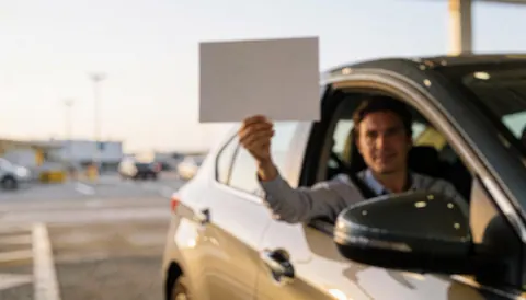 Taxi driver at airport holding sign with blurred background