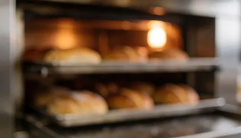 Background of an industrial oven with bread loaves in process, ideal for bakery text overlays