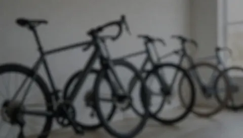 Background of a bicycle repair shop with bikes in a row, soft lighting, and neutral colors suitable for text overlay.