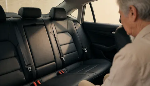 Close-up view of a black taxi back seat with a visible safety belt, highlighting safety features for a transportation service website.