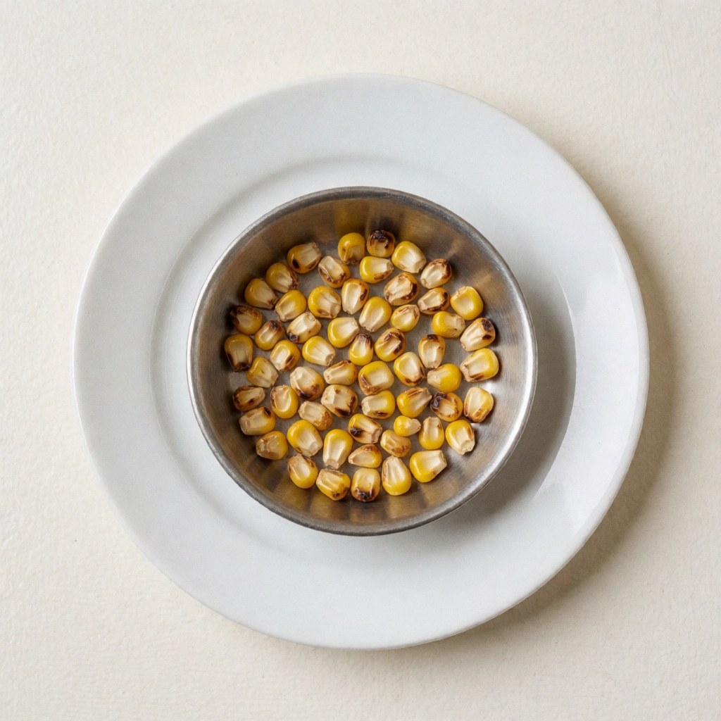 Grilled corn on a metal grill over a white plate with warm wall background, ideal for a poultry restaurant