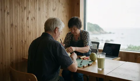 Green chirimoya fruit beer in a glass with chirimoya fruit on a wooden table with a wooden wall and sea view in a food establishment
