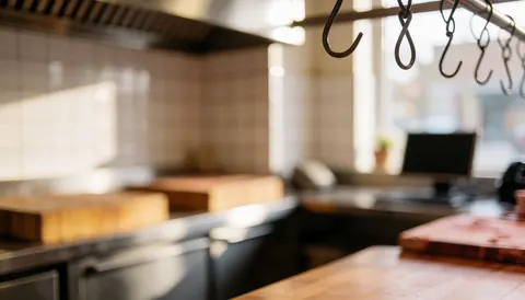 Meat hooks hanging in a butcher shop with cutting boards and white tiled walls, ideal for text overlay.