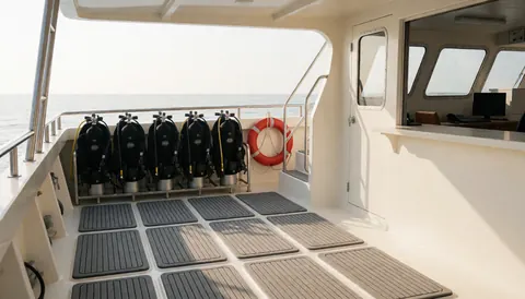 Scuba diving equipment including tanks and life rings arranged on a non-slip boat deck ready for an ocean excursion